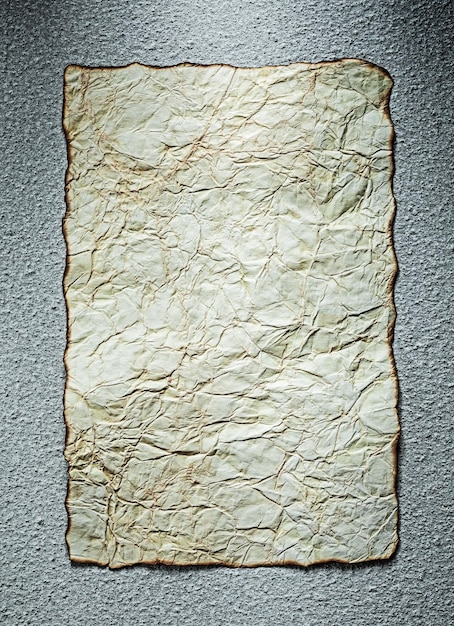 Feuille de papier froissé vintage sur fond gris.