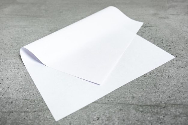 Feuille de papier vierge sur fond gris. Vue rapprochée de papier blanc plié portant sur un dessus de table stylisé en ciment