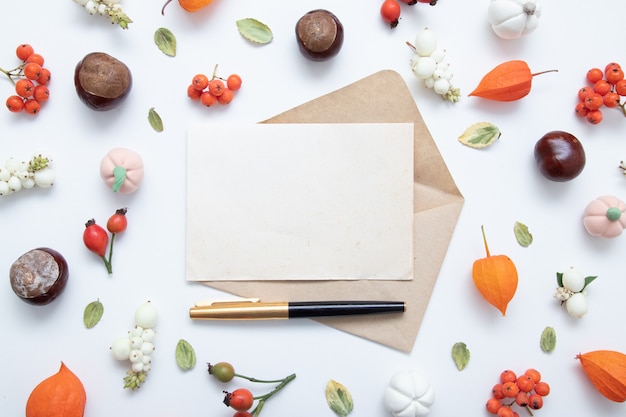 Feuille de papier vierge pour le texte et la mise en page d'automne avec physalis, pommes de pin, feuilles, rowan