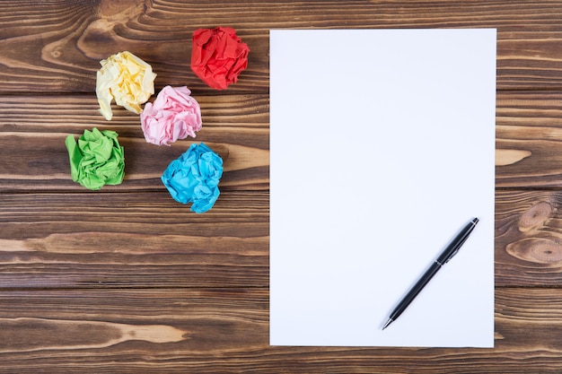 Feuille de papier vierge et stylo sur un bureau en bois clair