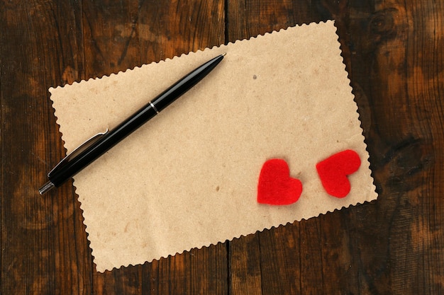 Feuille de papier vierge avec stylo et deux entend sur fond de table en bois rustique