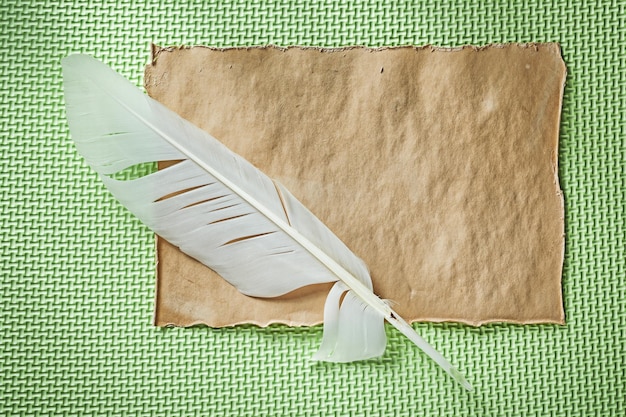 Feuille de papier vintage plume sur fond vert vue de dessus