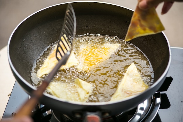 Feuille de pâte à friture dans de l&#39;huile très chaude.