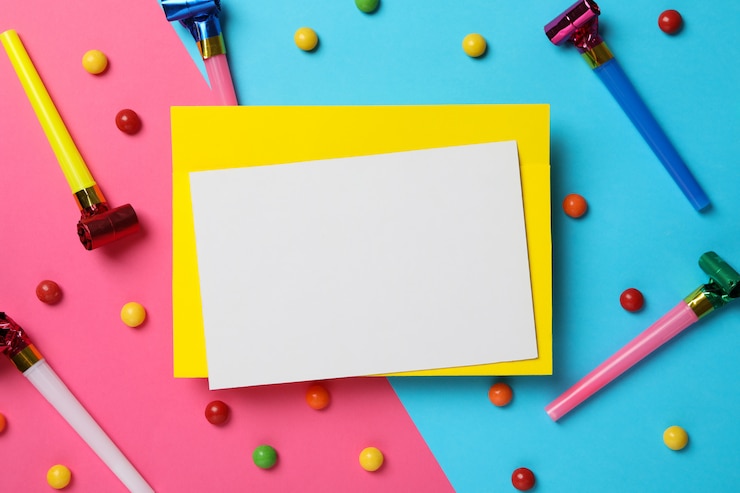 Photo feuille vide, sifflets d'anniversaire et bonbons sur fond bicolore, espace pour le texte