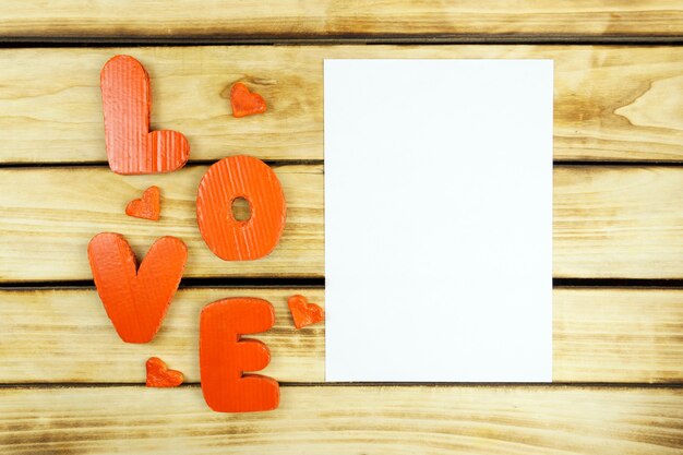 Feuille vierge à côté de lettres rouges écrites dans l'amour