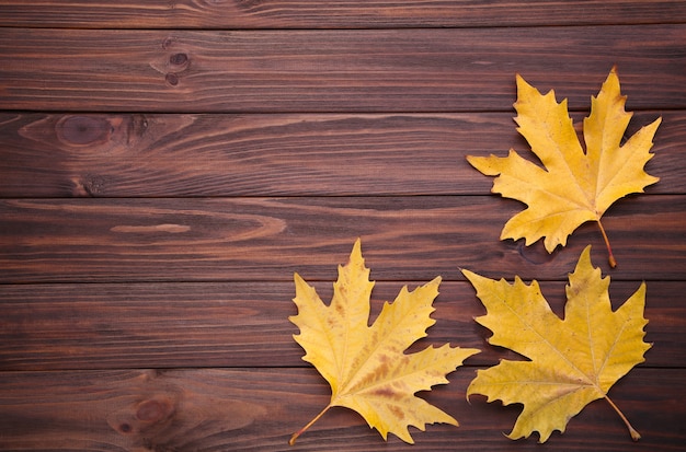 Photo feuilles d'automne orange sur une table marron. jour de thanksgiving