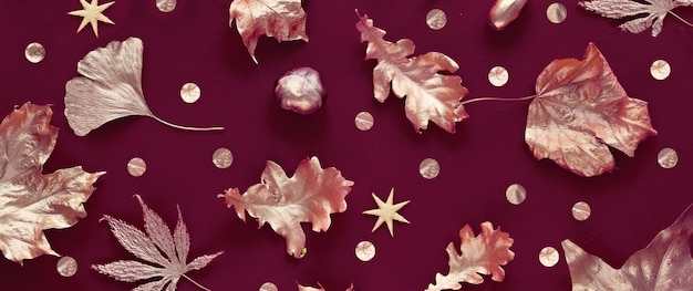 Feuilles d'automne avec peinture dorée métallique Mise à plat sur fond textile lin couleur bordeaux foncé