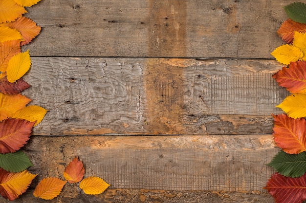 Feuilles d&#39;automne sur la surface de la table en bois