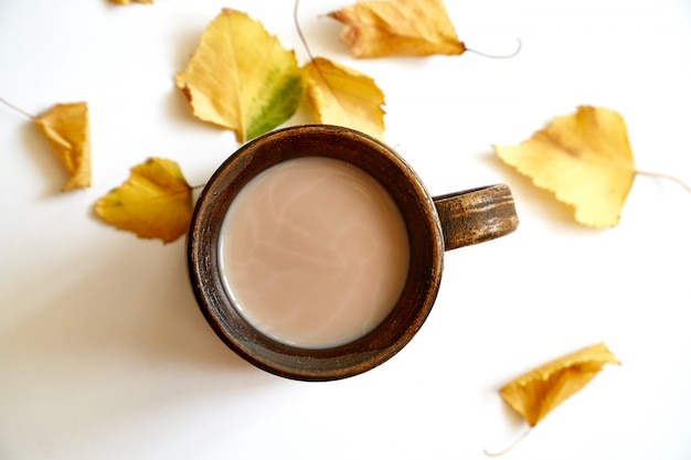 Feuilles d'automne avec une tasse de café ou de thé sur blanc