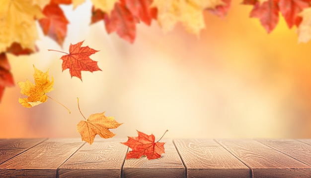 Feuilles d'automne tombant sur une table en bois