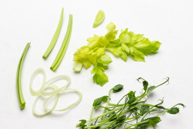 Feuilles de céleri et tiges pousses de pois Espace copie Mise à plat Fond blanc