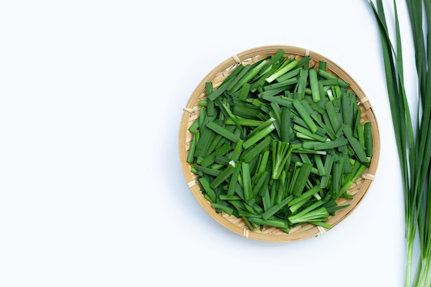 Feuilles de ciboulette chinoise fraîche sur fond blanc.