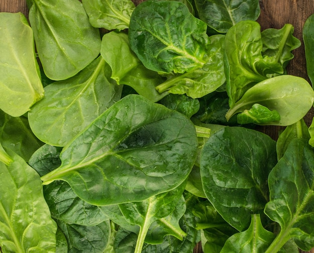 Feuilles d'épinards frais sur une table en bois