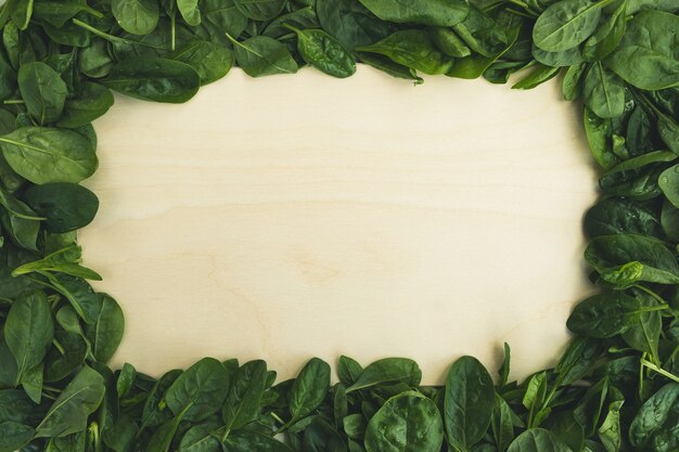 Feuilles d'épinards et planche à découper vide. Fond de nourriture, alimentation saine