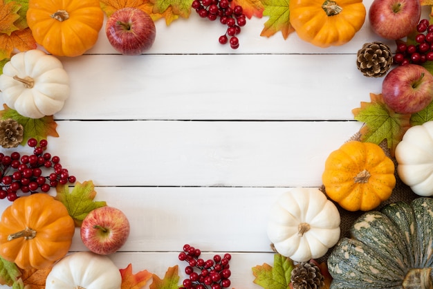 Feuilles D'érable Automne Avec Baies Citrouille Et Rouge Sur Bois Blanc. Concept De Jour De Thanksgiving