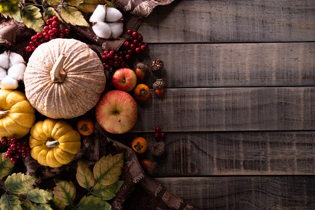 Photo feuilles d'érable automne avec citrouille sur fond en bois.