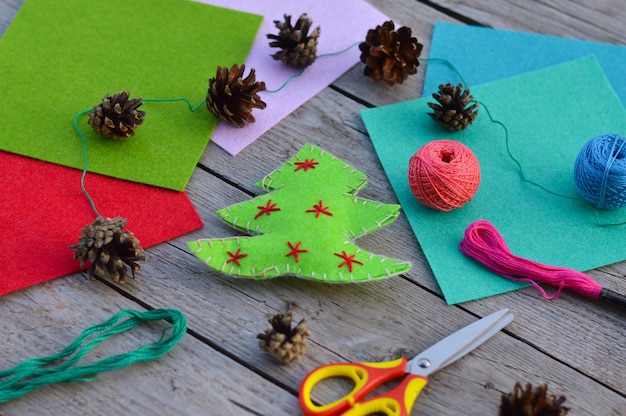 Feuilles de feutre fil de ciseaux sur table en bois Idée d'artisanat du Nouvel An pour les enfants Feutre vert à chevrons cousu de vos propres mains