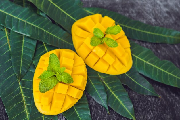 Feuilles de mangue et mangue sur un vieux fond en bois