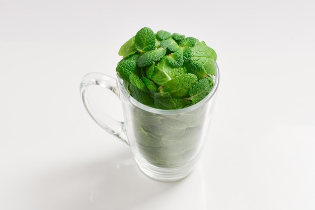 Feuilles de menthe dans une tasse isolé sur fond blanc