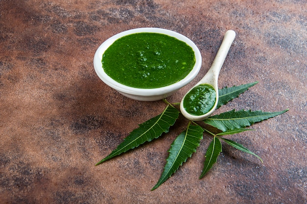 Photo feuilles de neem médicinales avec de la pâte sur la surface de la pierre