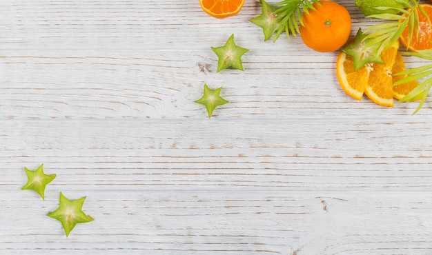 Feuilles de palmier vertes et tranches de fruits tropicaux frais