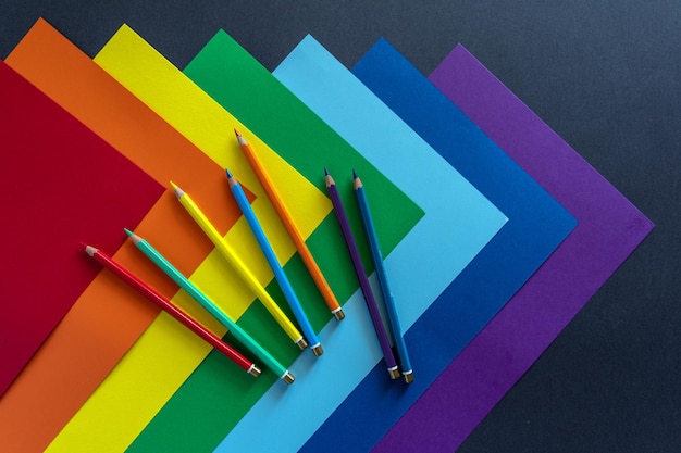 Feuilles de papier multicolore avec des crayons de couleur. Couleurs de l'arc-en-ciel. Symbole de la communauté LGBT