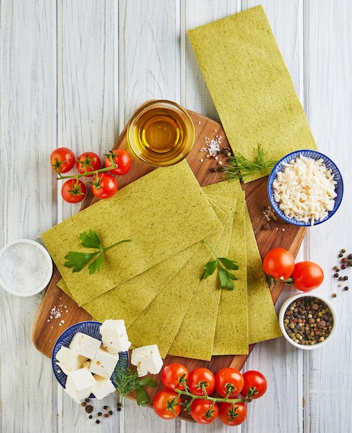 Feuilles pour faire des lasagnes aux épinards et ingrédients tomates cerises, fromage