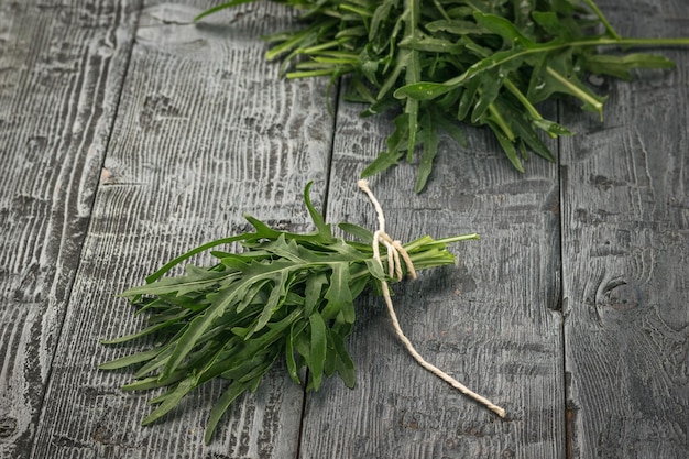 Feuilles de roquette attachées avec une corde sur une table rustique noire