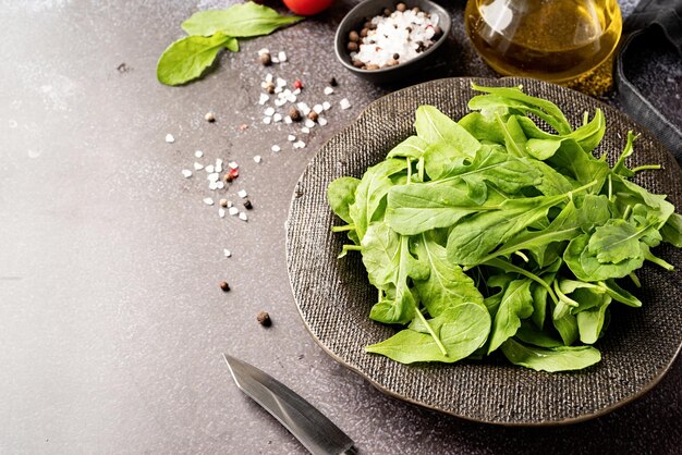 Feuilles de roquette fraîches dans un bol noir avec espace de copie de légumes frais