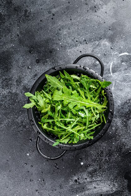 Feuilles de roquette fraîches dans une passoire