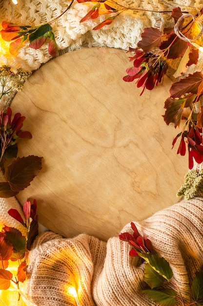 Photo feuilles rouges et une estrade sur fond chaud textile. concept de l'automne. vue d'en-haut.