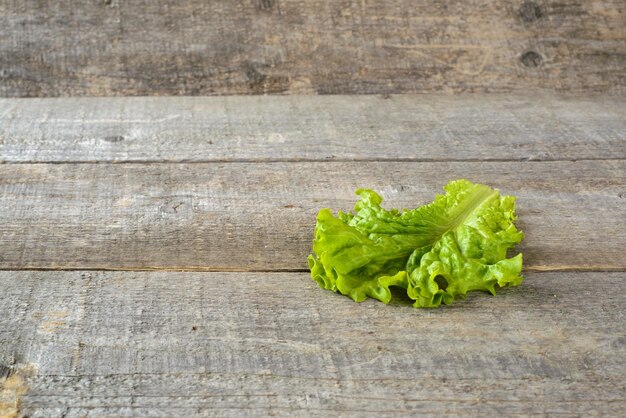 Feuilles de salade verte d'aliments biologiques sur fond rustique