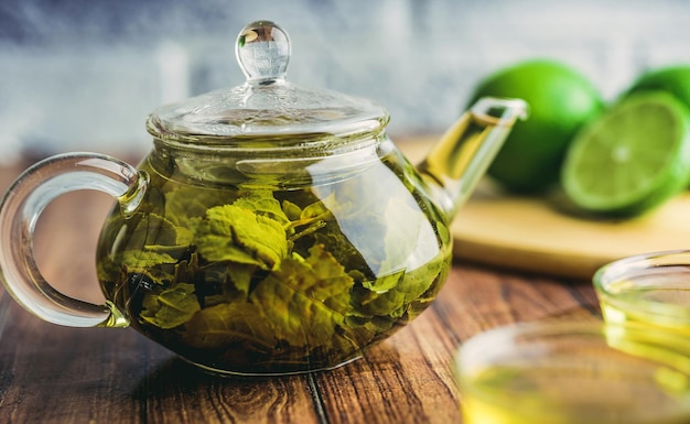 Les feuilles de thé sont infusées dans de l'eau bouillante et infusées dans une petite théière Le concept de la tea party Thé vert dans une théière