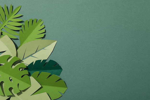 Feuilles tropicales vertes en papier sur fond vert avec un oiseau flamant rose