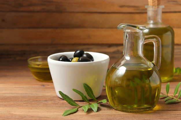 Feuilles vertes d'huile d'olive et olives sur la table