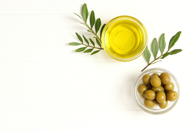 Feuilles vertes d'huile d'olive et olives sur la table