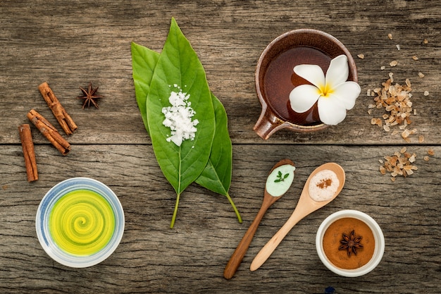 Feuilles vertes avec des ingrédients de spa nature sur fond rustique.