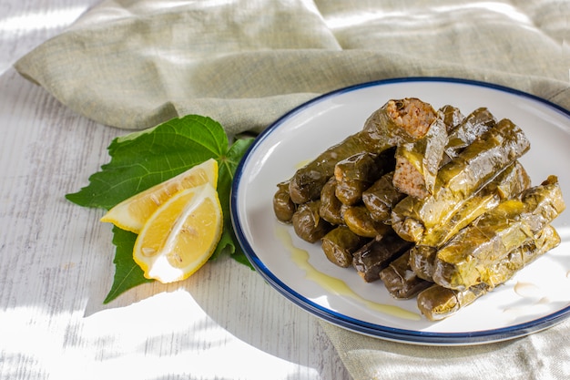 Feuilles de vigne farcies de riz et d'épices, servies avec de l'huile d'olive et du citron frais