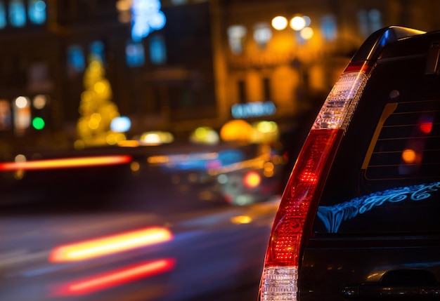 Feux arrière d'une voiture noire closeup soir ville