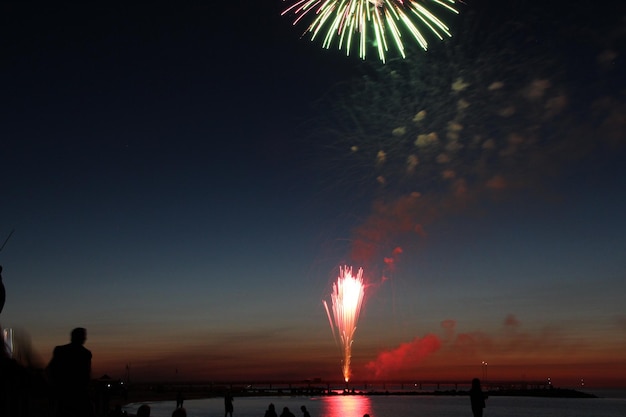 Photo feux d'artifice sur la mer contre le ciel la nuit