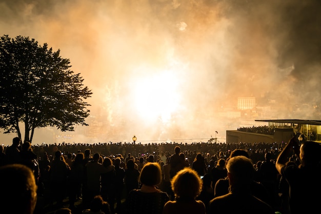 Feux d'artifice qui explosent dans le festival au-dessus des gens la nuit.