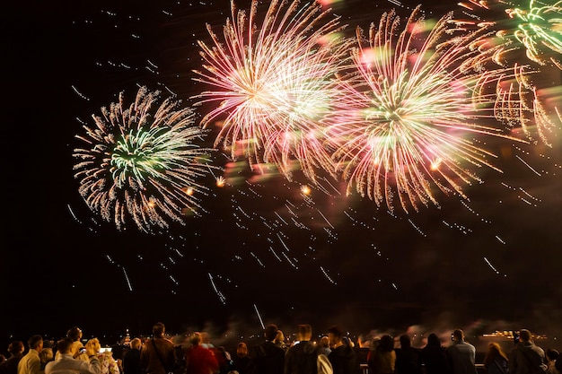 Feux d'artifice avec des silhouettes de personnes lors d'événements de vacances