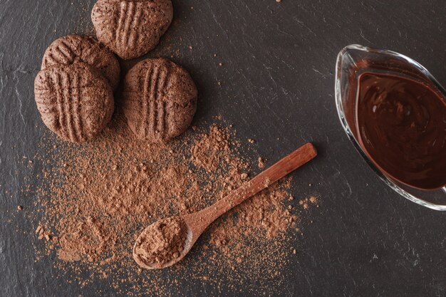 Fèves de cacao et poudre de cacao sur une cuillère en bois