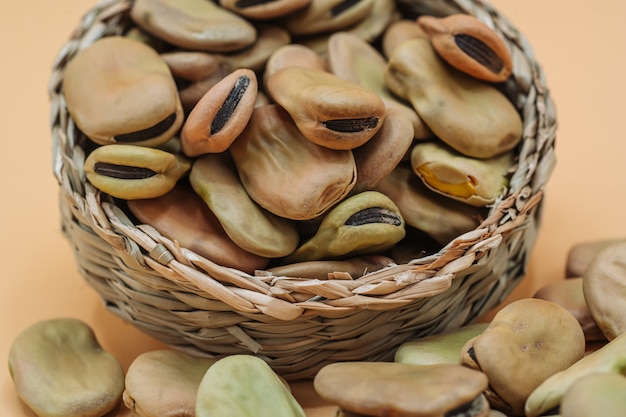 Fèves sèches biologiques saines dans un panier de paille