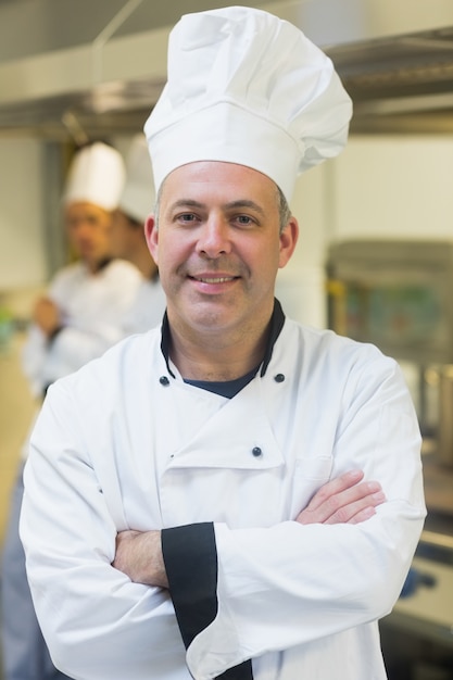 Fier chef mature posant dans une cuisine