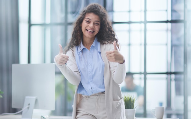 Fier employé de bureau posant avec les pouces vers le haut