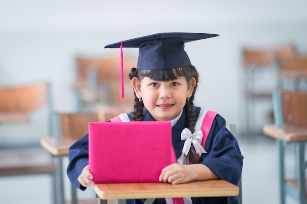 Un fier enfant diplômé vêtu d'une toge et d'une casquette symbolisant la réussite et la réussite éducatives