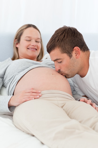 Fier futur papa embrasser le ventre de sa femme