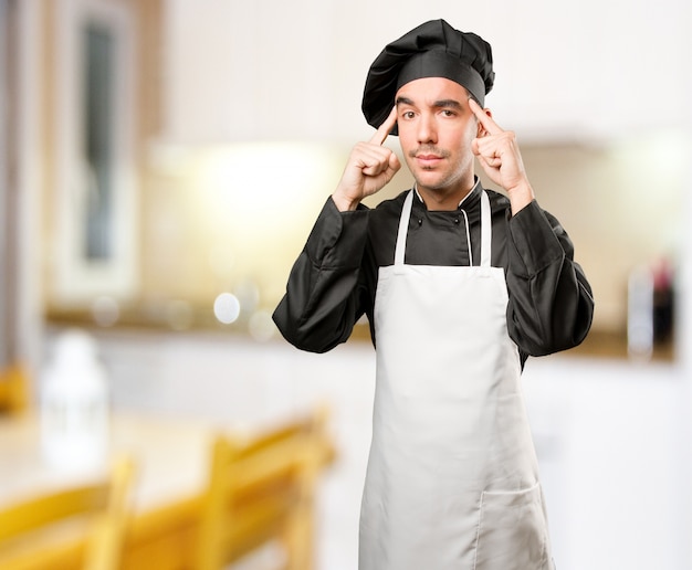 Fier jeune chef faisant un geste de concentration