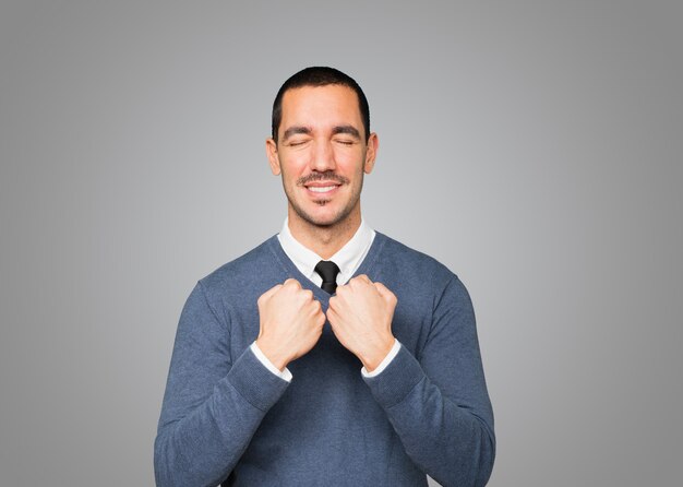 Fier jeune homme faisant un geste de force avec son bras